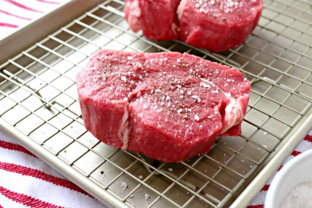 uncooked filets on a roasting pan with salt and pepper